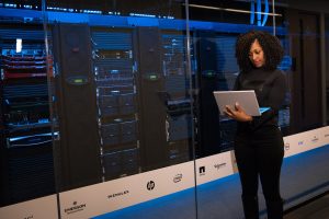 software engineer standing beside server racks